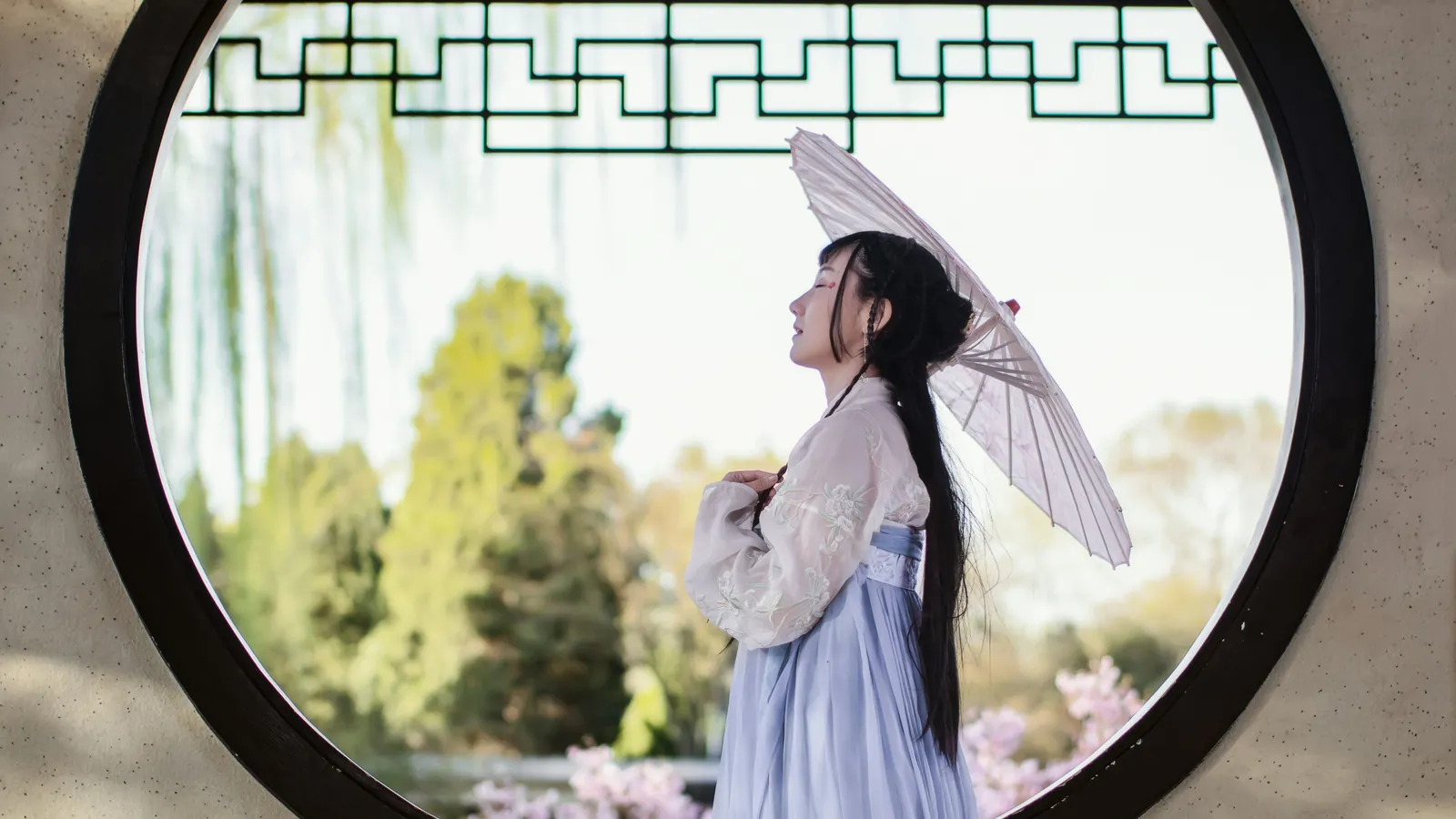 妖精视频造型导读氛围图：圆形窗洞外撑着纸伞的汉服女子